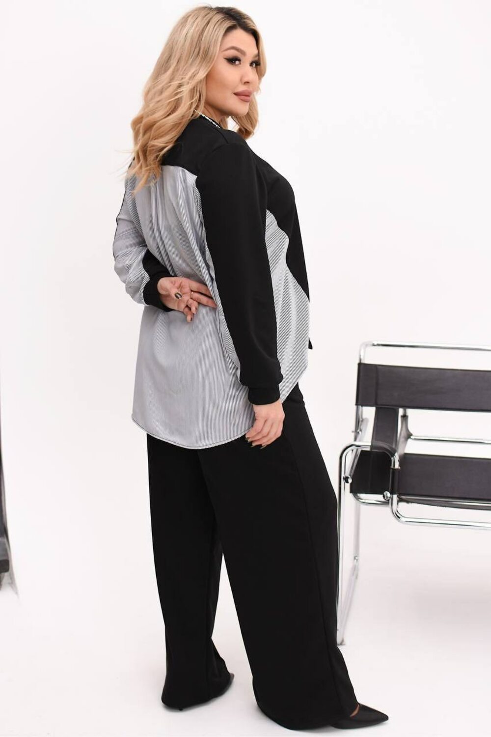 Костюм двійка складається з кофти з подовженою спиною та брюк палаццо. Колір чорний.