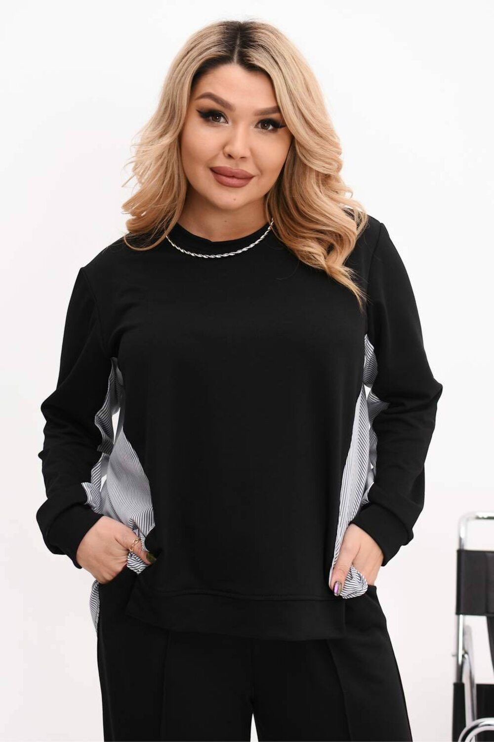 Костюм двійка складається з кофти з подовженою спиною та брюк палаццо. Колір чорний.