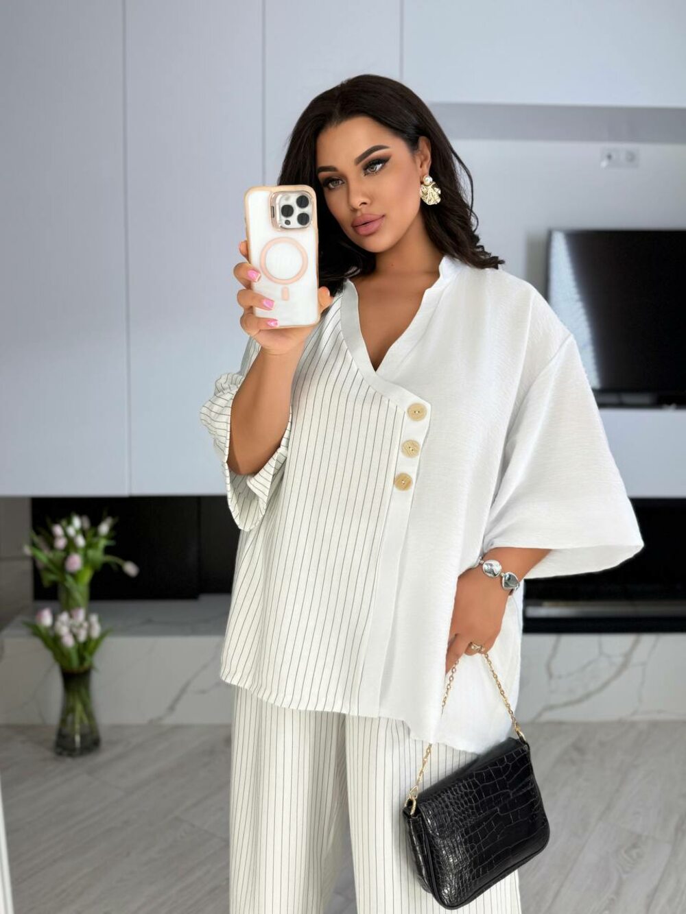 Костюм складається з брюк та блузи з коротким рукавом, колір білий