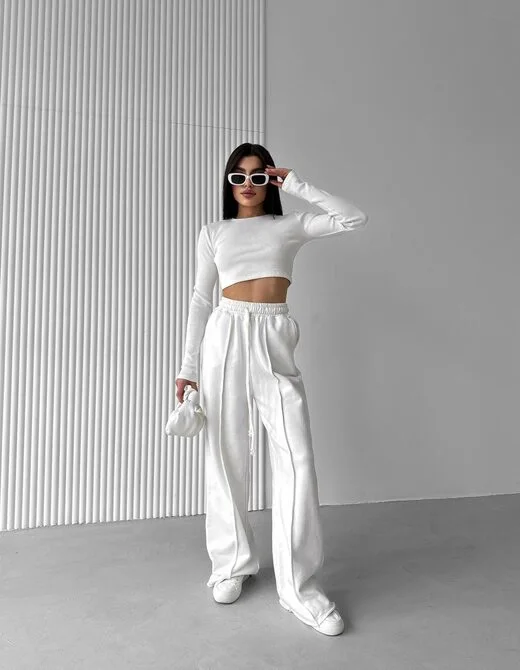 Спортивный костюм состоит из штанов и укороченного лонгслива, цвет молочный