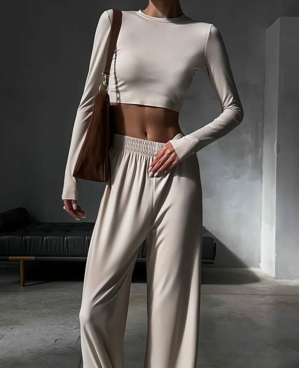 Костюм двійка з ідеальною посадкою, укорочена кофточка підкреслює фігуру, штани вільного крою на високій посадці. Колір бежевий.