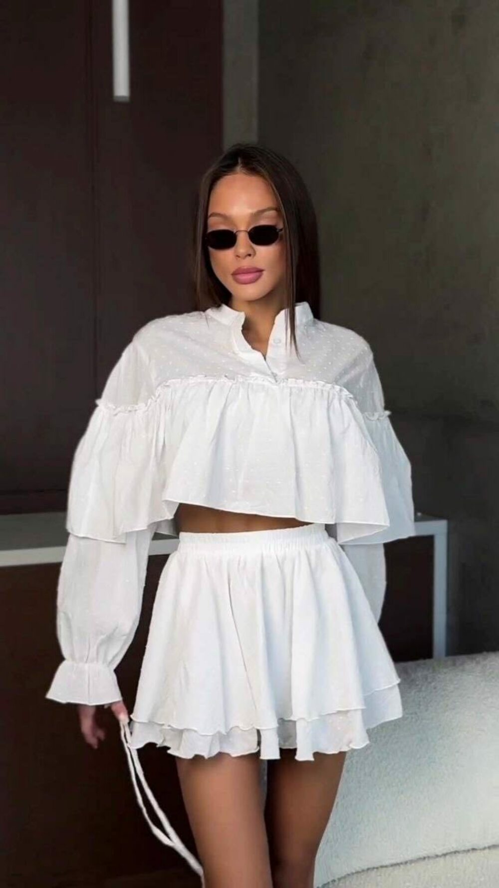 Вільний костюм складається з укороченої блузи з довгими рукавами та міні-спідниці, колір білий
