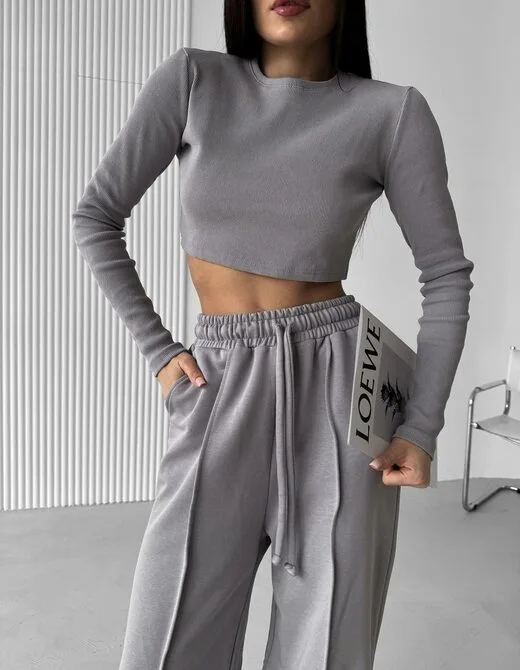 Спортивный костюм состоит из штанов и укороченного лонгслива, цвет серый