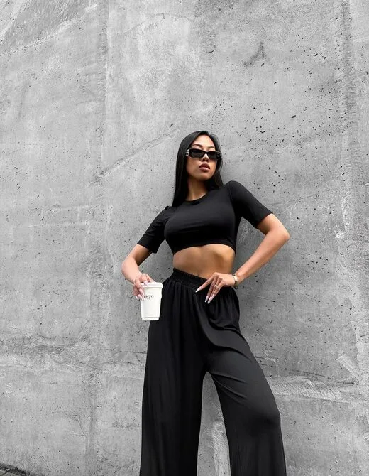 Костюм состоит из укороченного топа и брюк, цвет черный
