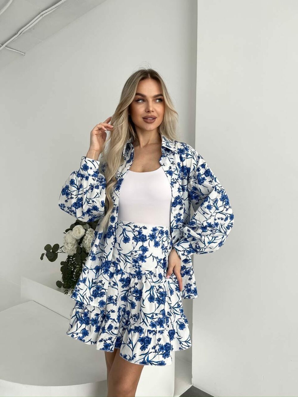 Комплект складається з сорочки з подвійною планкою спереду, що застібається на гудзики. Колір принт синій на білий основі. Спідниця ззаду має еластичний пояс, завдяки чому ідеально сідає по фігурі.