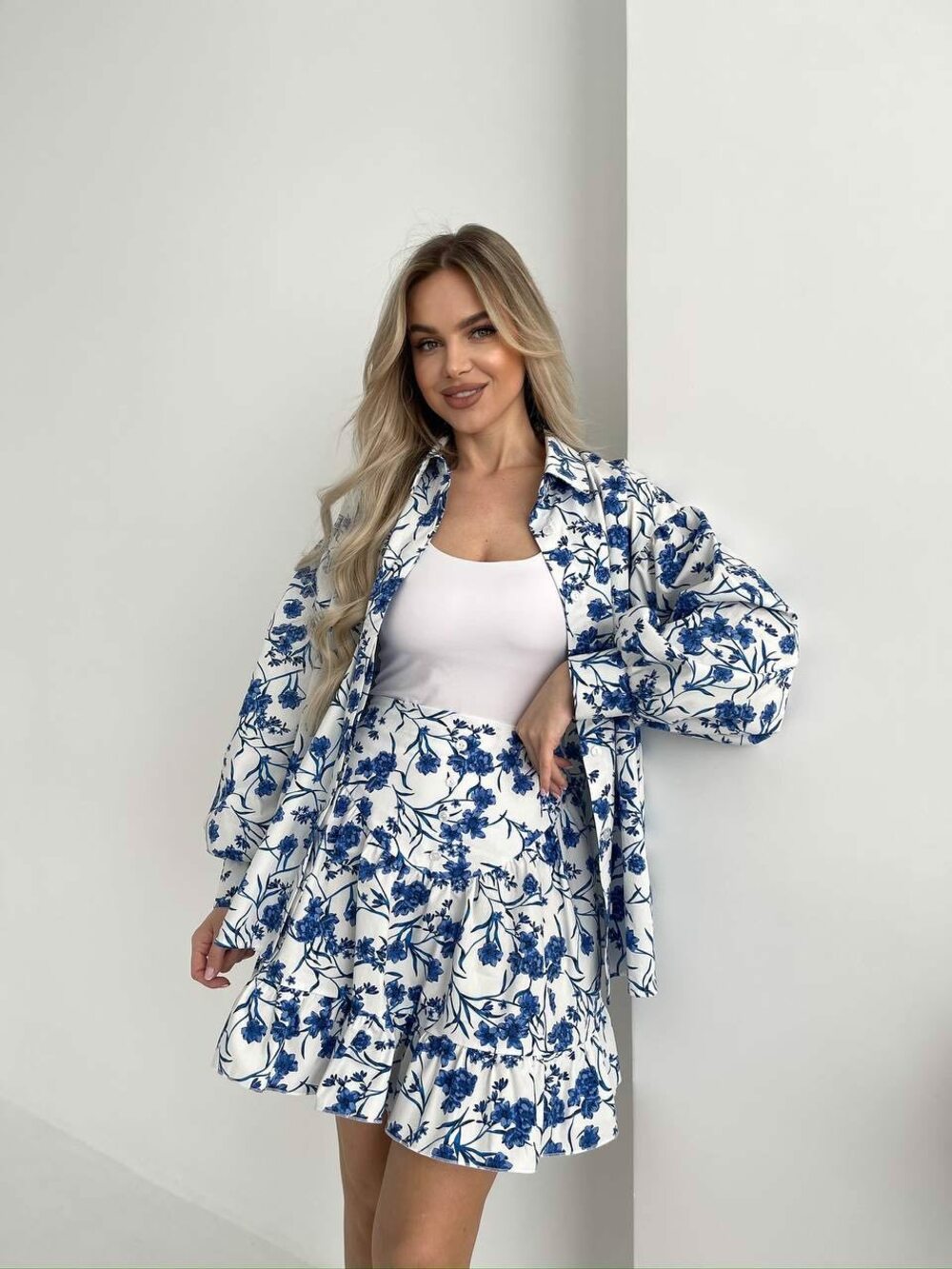 Комплект складається з сорочки з подвійною планкою спереду, що застібається на гудзики. Колір принт синій на білий основі. Спідниця ззаду має еластичний пояс, завдяки чому ідеально сідає по фігурі.
