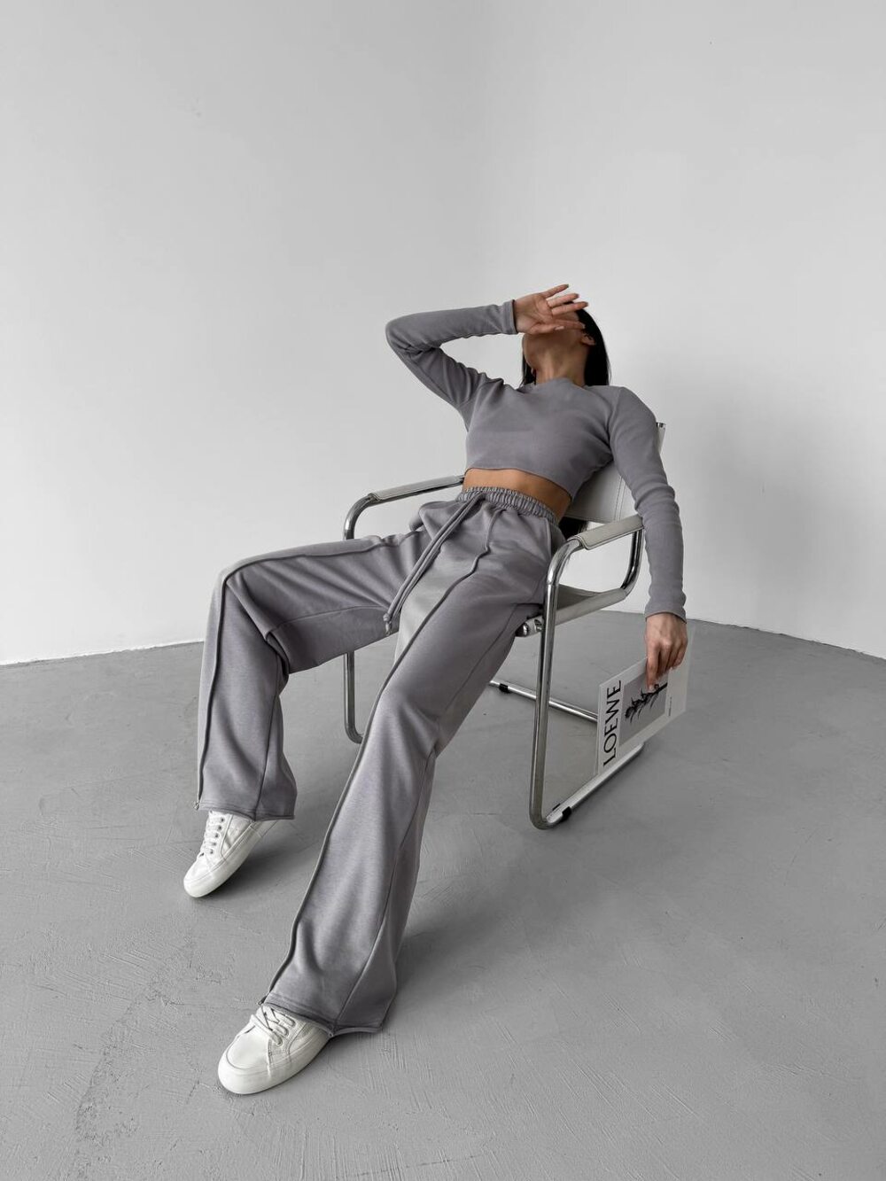 Спортивный костюм состоит из штанов и укороченного лонгслива, цвет серый