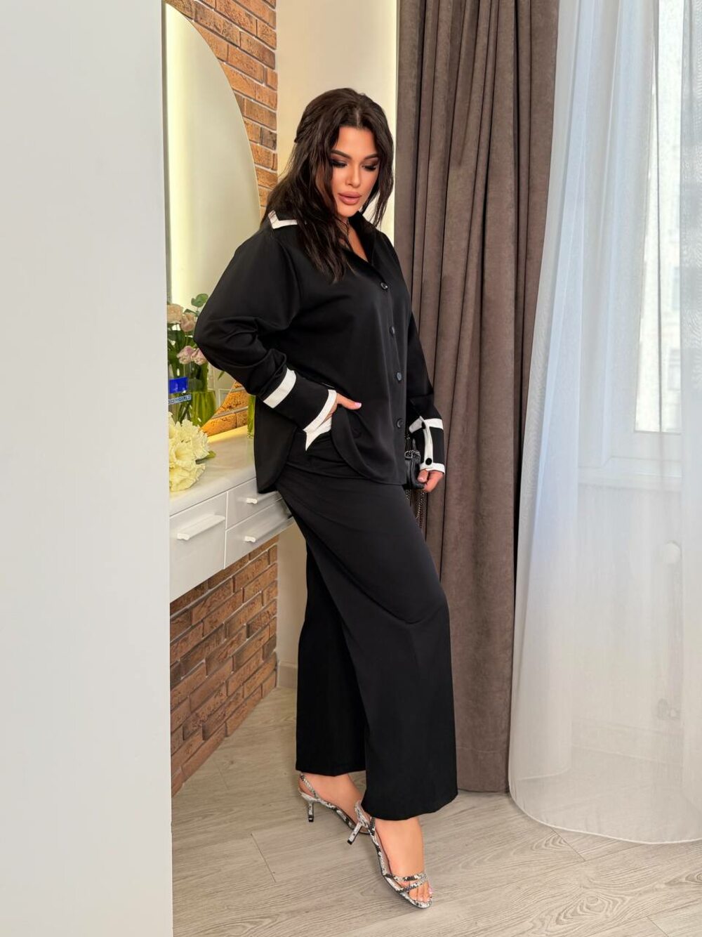 Костюм складається з штанів з кишенями та блузки, колір чорний