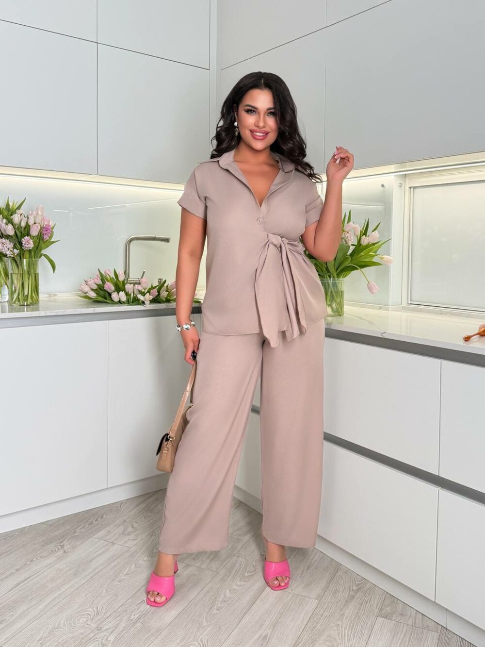 Костюм складається з брюк та блузи оригінального крою, колір бежевий.