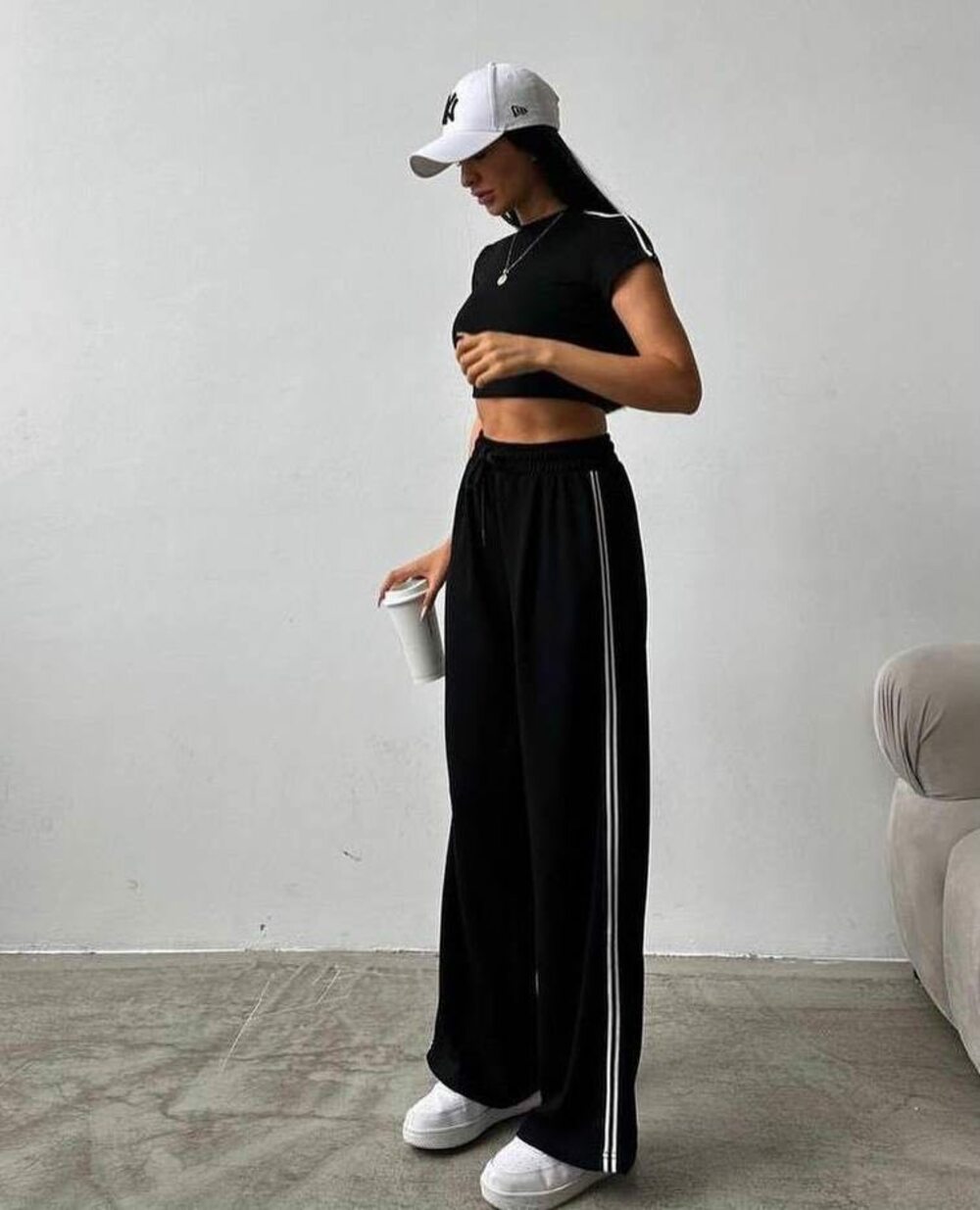 Спортивний костюм складається з укороченого топа та брюк з лампасами на гумці, колір чорний