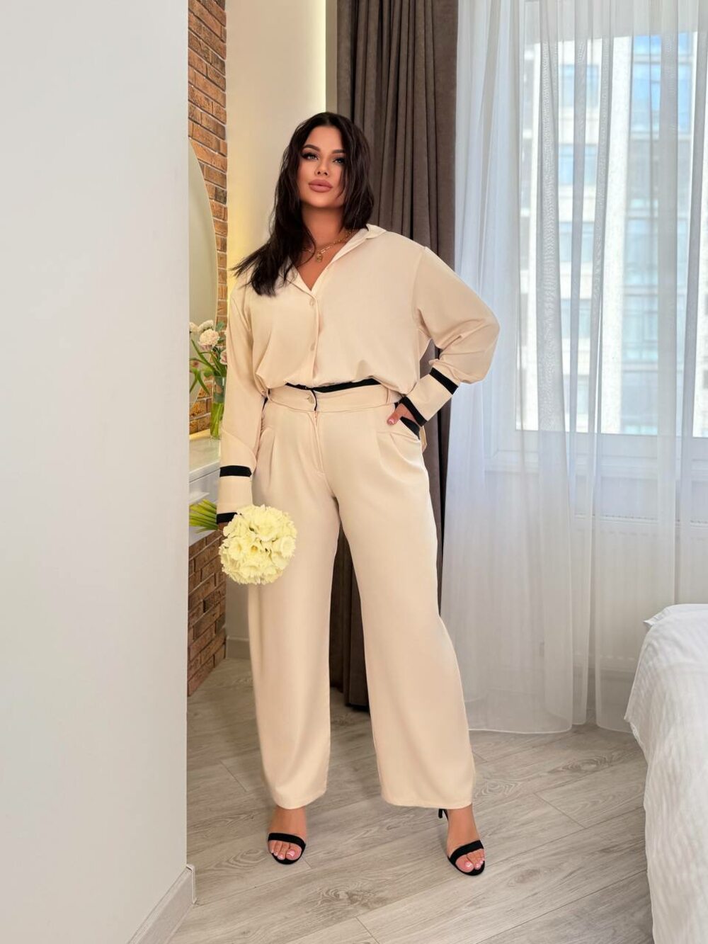 Костюм складається з штанів з кишенями та блузки, колір бежевий.