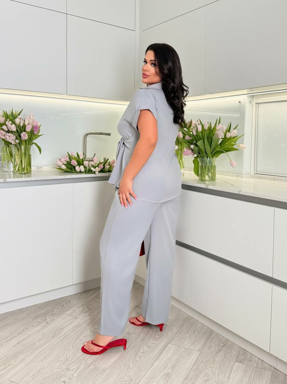Костюм складається з брюк та блузи оригінального крою, колір сірий