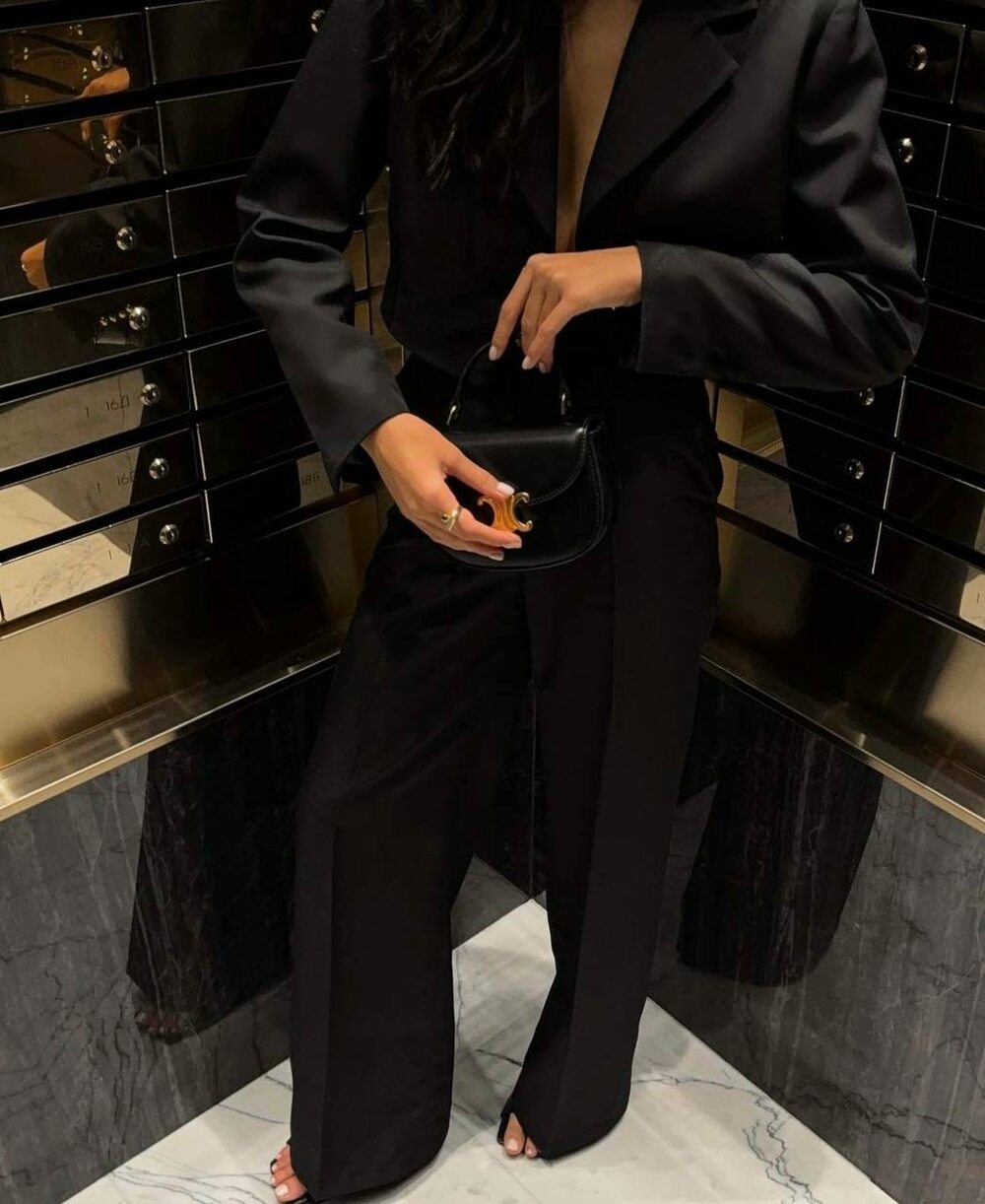 Костюм двійка складається з штанів палаццо та вкороченого піджака. Штани на високій посадці, кльош від стегна, піджак з плічками застібається на гудзики. Колір чорний