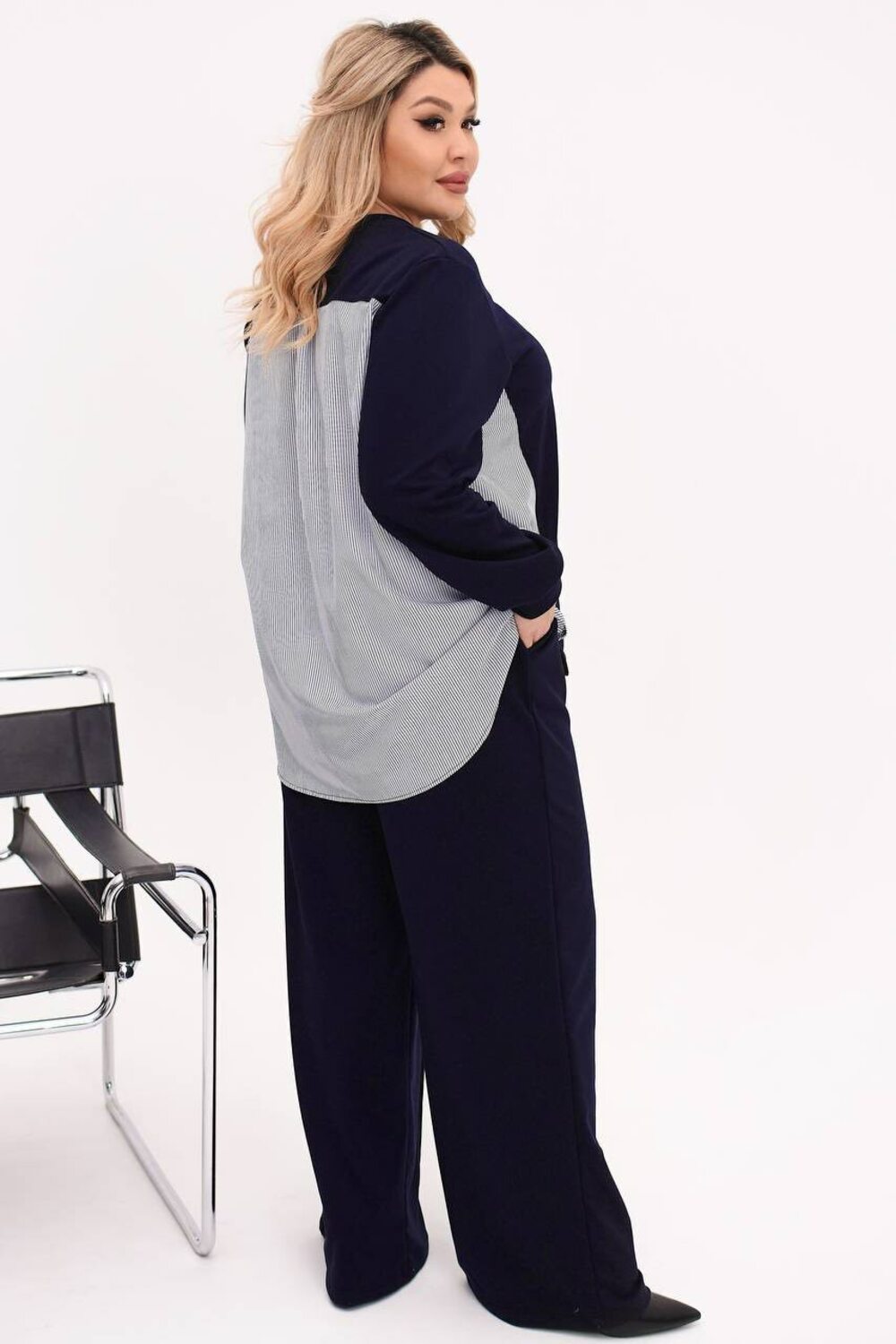 Костюм двійка складається з кофти з подовженою спиною та брюк палаццо. Колір темно-синій.