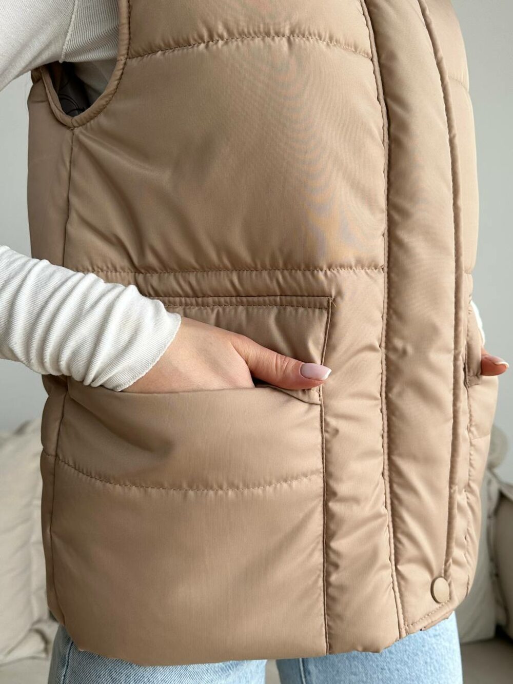 Коричнева жилетка з кнопками і коміром.