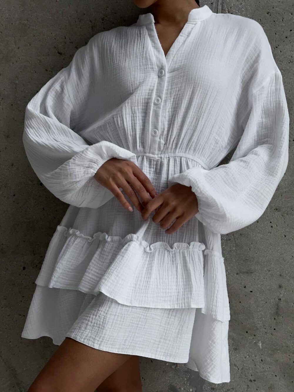 Стильна муслінна сукня. Верх застібається на гудзики, по низу волан рюш, талія на резинці. Колір білий.